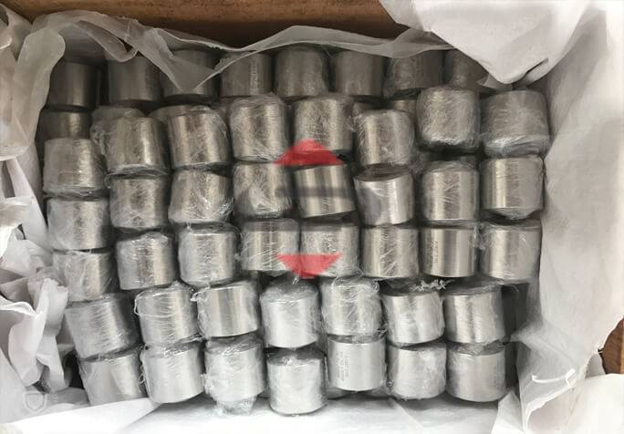 A Group Of Silver Cylindrical Stainless Steel Pipes In Plastic Wrap